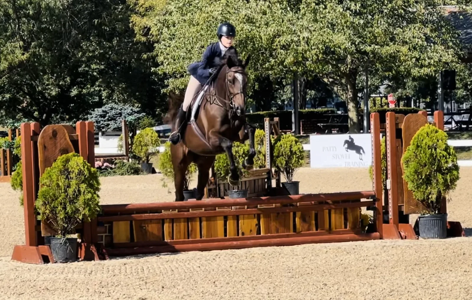 A horse and rider clearing a jump in the arena at Bittersweet Acres Farm