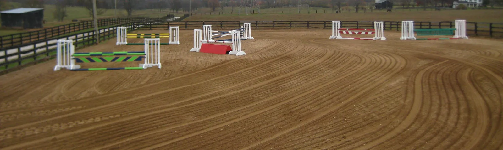 Wide view of the outdoor riding arena and jumps